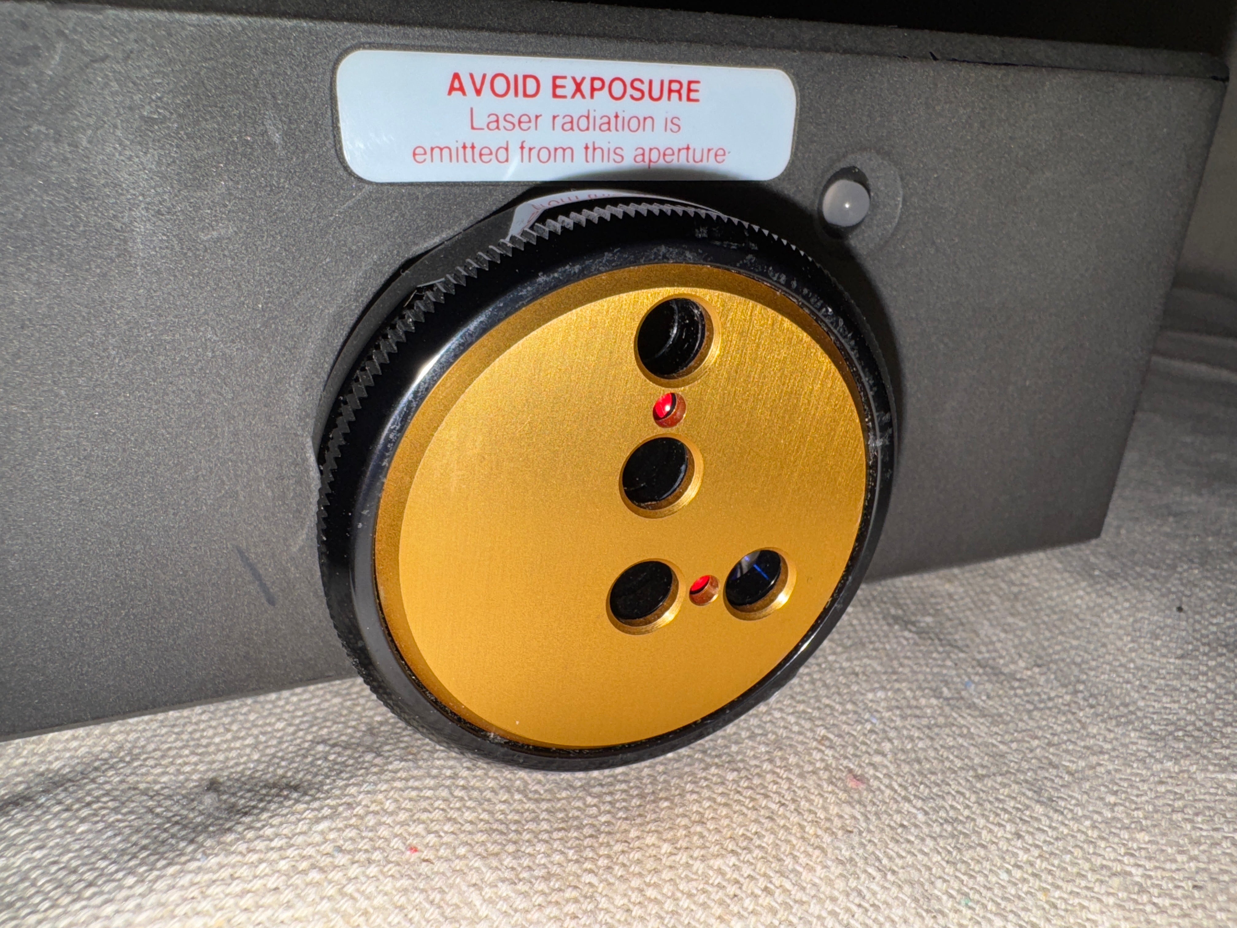 Detail of the Renishaw ML10 X Laser Interferometer showing the laser aperture and warning label.