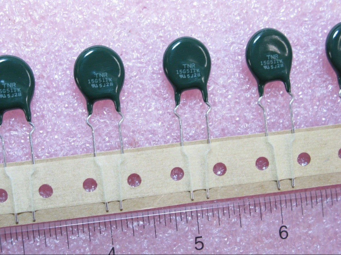 10 QTY MARCON TNR15G511K-T1 14MM Varistor components displayed on a ruler for size comparison.