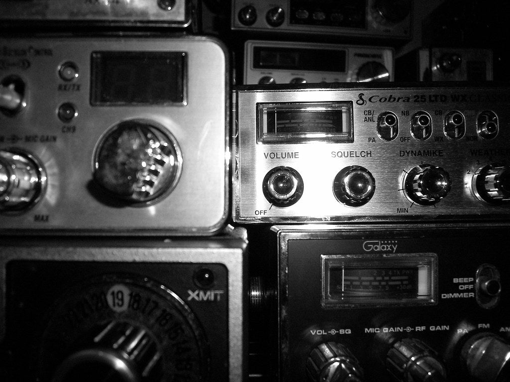 CB Radio Mail In Repair Service Estimate displayed among various CB radios and their controls.